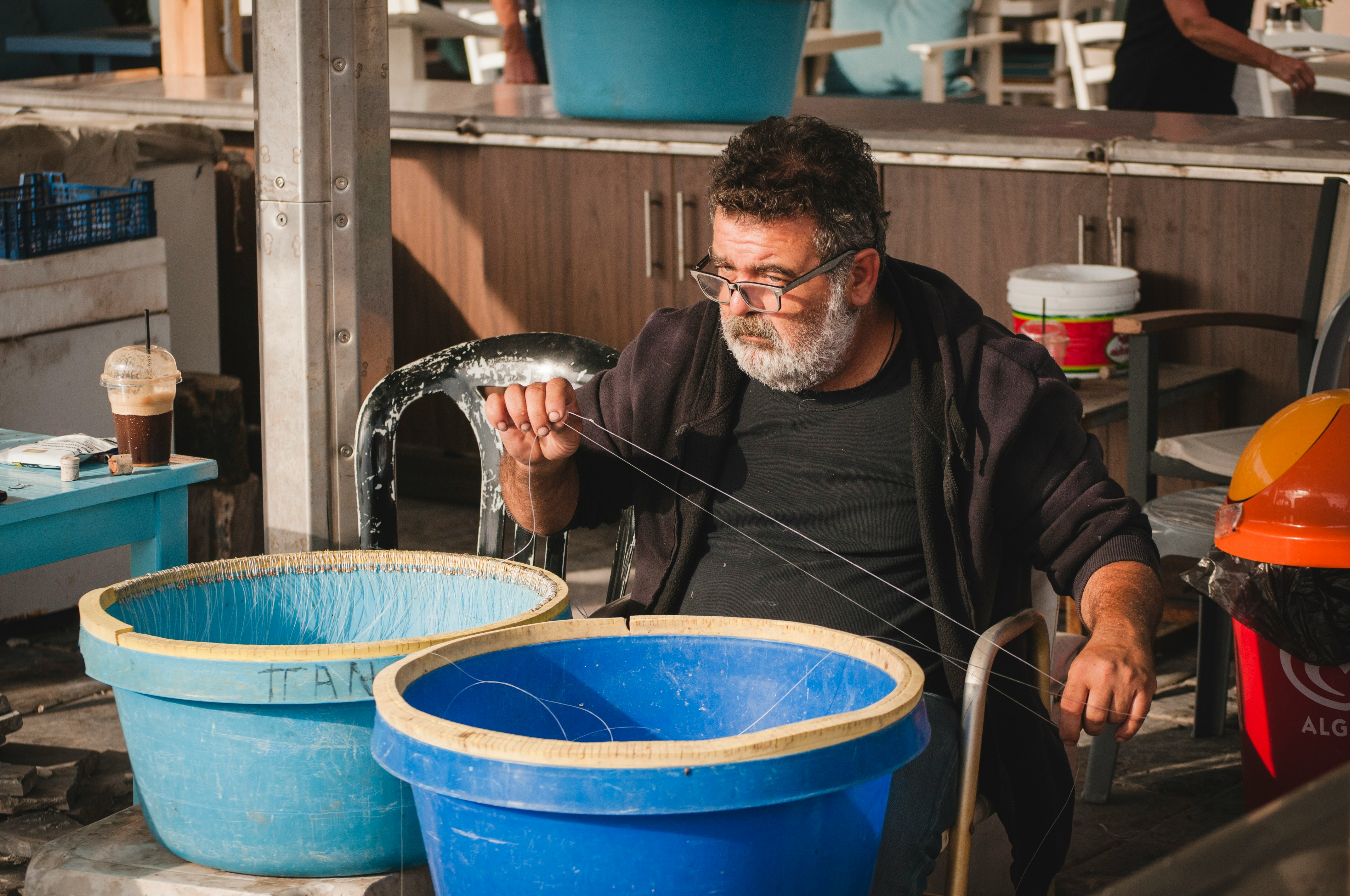 man sitting on chair near two blue pots